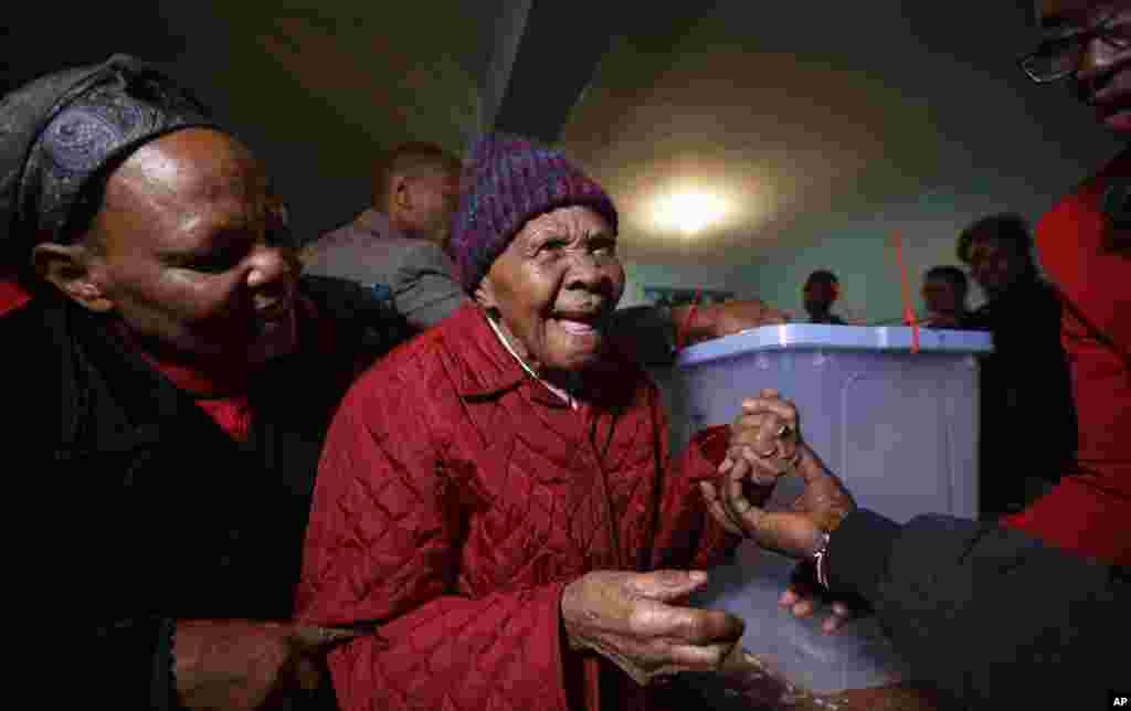 Lydia Gathoni Kiingati, 102, reacts after having her finger inked, after casting her vote just after dawn at a polling station in Gatundu, north of Nairobi, Kenya, Aug. 8, 2017.