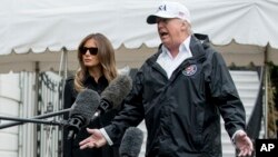 President Donald Trump accompanied by first lady Melania Trump, speaks to members of the media on the South Lawn of the White House in Washington, Sept. 14, 2017.