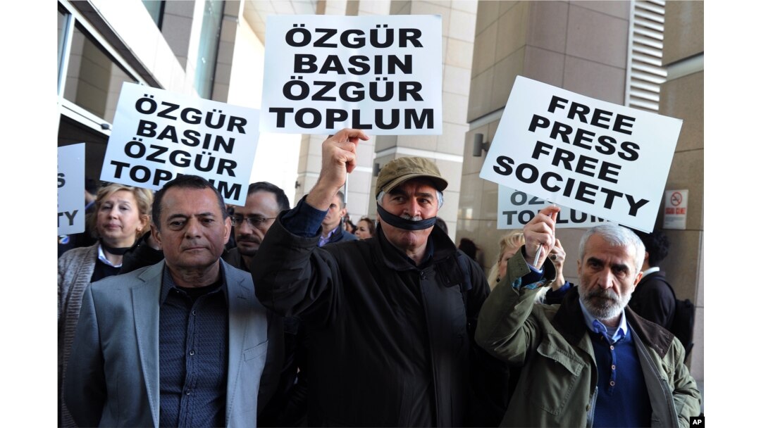 Turkish journalists cover their mouths with black ribbons before the trial of Can Dundar, the editor-in-chief of opposition newspaper Cumhuriyet and Erdem Gul, the paper's Ankara representative, outside the courthouse in Istanbul, April 1, 2016.
