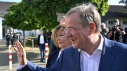 Armin Laschet, leader of Germany's conservative Christian Democratic Union (CDU) party and candidate for Chancellor, and his wife Susanne Laschet (L) leave after voting at a polling station in Aachen, western Germany, Sept. 26, 2021