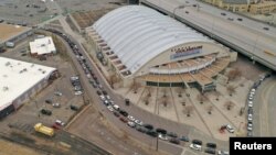 Antrean mobil tampak di Stadion Denver Coliseum yang didatangi warga untuk menjalani tes virus (COVID-19) di stasiun pengujian lantatur di Denver, Colorado, 14 Maret 2020. 