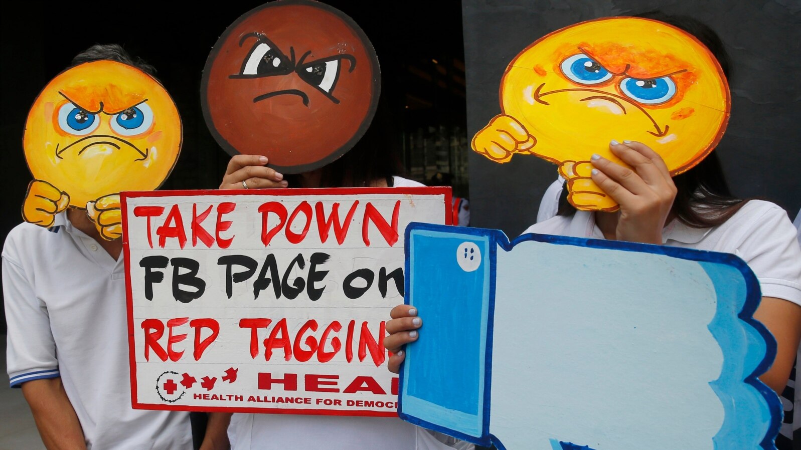 FILE - People covering their faces with "angry emoji" cutouts protest Facebook's alleged inaction against fake news, hate speech and red-tagging of activists, in suburban Taguig city, east of Manila, Philippines, May 9, 2019. 