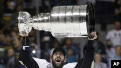 Pittsburgh Penguins defenseman Justin Schultz raises the Stanley Cup after Game 6 of the NHL hockey Stanley Cup Finals against the San Jose Sharks, June 12, 2016.