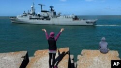 Una persona despide al destructor Sarandi mientras sale de la base naval en Mar del Plata, Argentina.