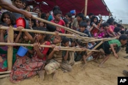 FILE - Rohingya Muslim children, who crossed over from Myanmar into Bangladesh, are squashed together as they wait to receive food handouts distributed to children and women by a Turkish aid agency at Thaingkhali refugee camp, Bangladesh, Oct. 21, 2017.