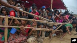 FILE - Rohingya Muslim children, who crossed over from Myanmar into Bangladesh, are squashed together as they wait to receive food handouts distributed to children and women by a Turkish aid agency at Thaingkhali refugee camp, Bangladesh, Oct. 21, 2017. Conditions for the hundreds of thousands of Rohingya refugees are still dire, with most living in overcrowded, muddy and squalid camps.