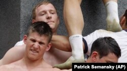 Plebes form a human pyramid to climb the Herndon Monument at the U.S. Naval Academy in 2012.