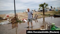 Čovek hoda selom Nea Plagia koje je pogođeno olujom
