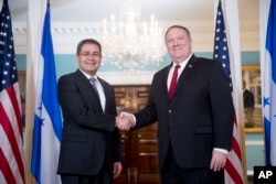 Secretary of State Mike Pompeo, right, shakes hands with Honduran President Juan Orlando Hernandez, left, at the State Department in Washington, June 18, 2018.