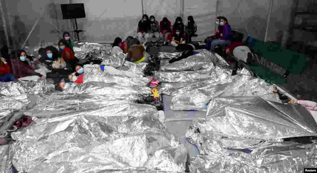 Migrants lie on mattresses inside a temporary processing facility for migrants, including unaccompanied minors, in Donna, Texas, in this handout photo provided by the U.S. Customs and Border Protection agency.