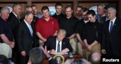 FILE - President Donald Trump reacts after signing an executive order eliminating Obama-era climate change regulations at the Environmental Protection Agency in Washington, March 28, 2017.