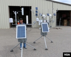 Technician Justin checks high-tech, portable weather stations before they are packed up for the next incident, July 2015. (VOA/T. Banse)