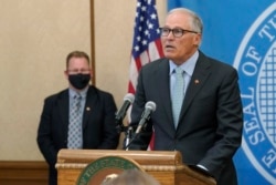 Gubernur Washington Jay Inslee (kanan) dalam konferensi pers di Capitol di Olympia, 18 Agustus 2021.