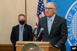 Washington Gov. Jay Inslee, right, speaks at a news conference, Aug. 18, 2021, at the Capitol in Olympia.