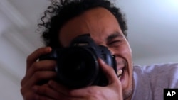 Mahmoud Abu Zaid, a photojournalist known as Shawkan, poses with his colleague's camera at his home in Cairo, Egypt, March 4, 2019. Shawkan was released after five years in prison.