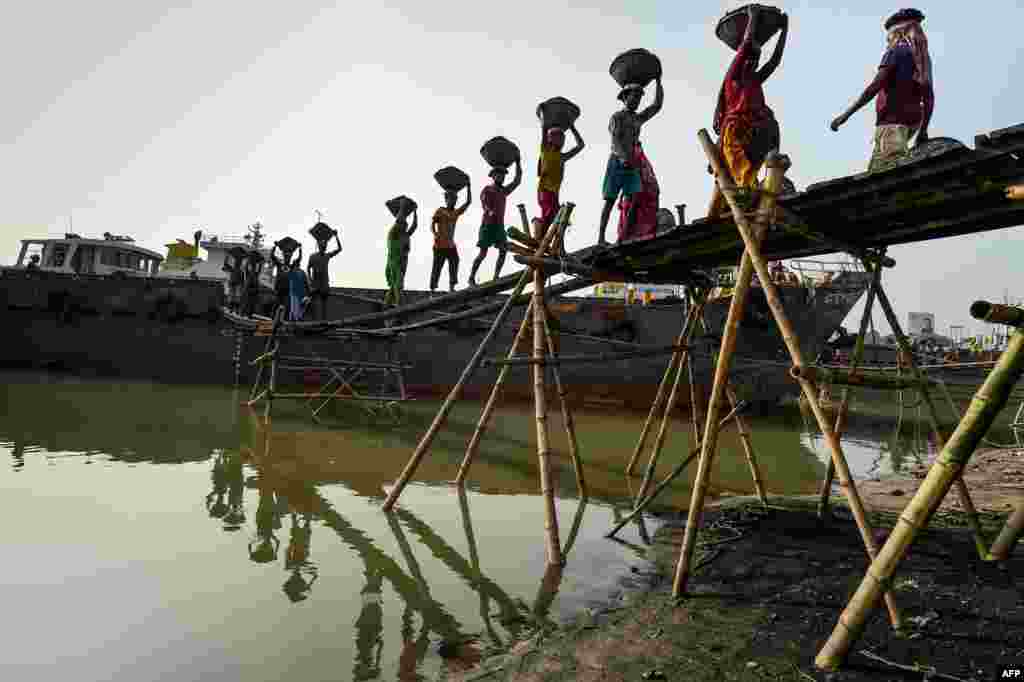 Laborers remove coal from a cargo ship in Gabtoli on the outskirts of Dhaka, Bangladesh.