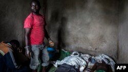 A health worker works to clean and dress the bodies of a young boy and man, who were killed the night before, allegedly by rebels from the Allied Democratic Forces, Oct. 5, 2018, in Beni, Democratic Republic of the Congo.