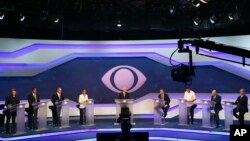 FILE - Debate mediator Ricardo Boechat, center, stands with Brazil's presidential candidates before the start of a debate in Sao Paulo, Brazil, Aug. 9, 2018.