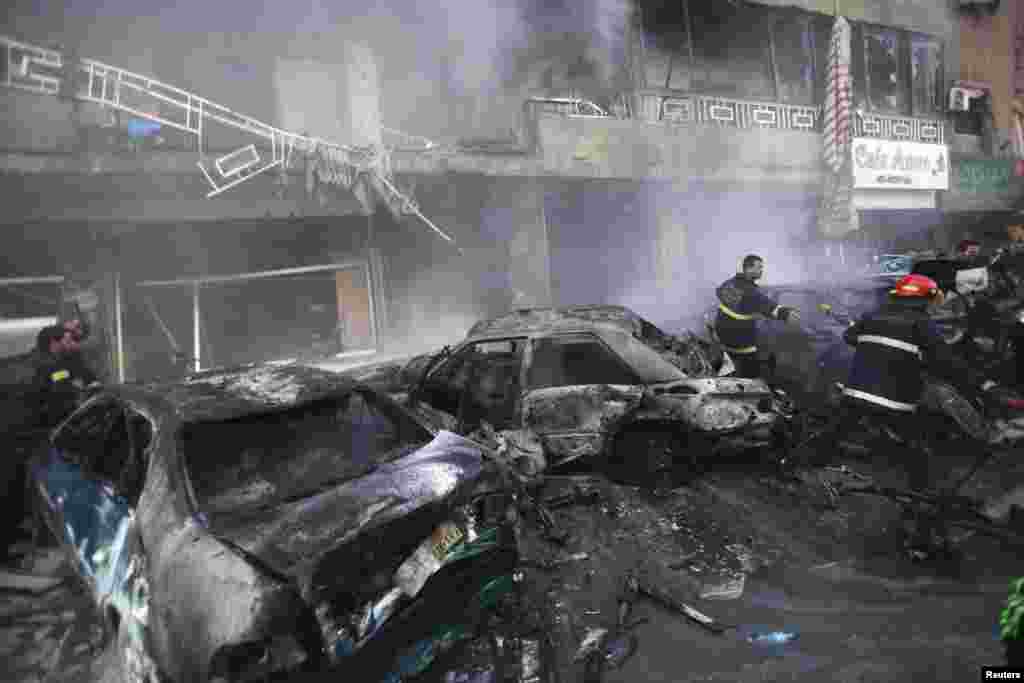 Civil defense members extinguish a fire at the site of an explosion in Haret Hreik, Beirut, Jan. 21, 2014.