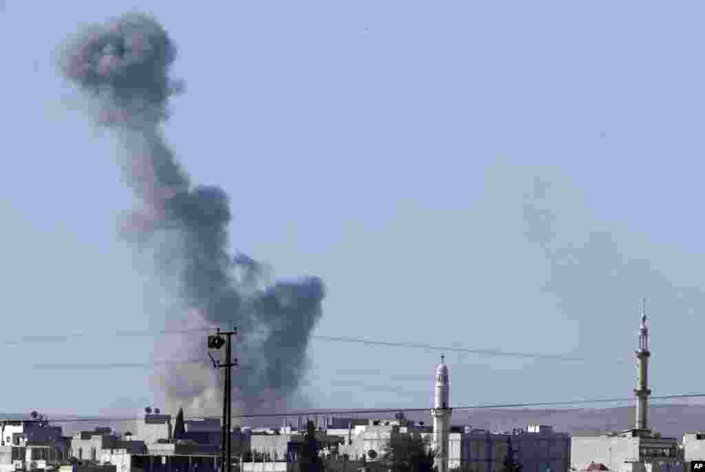 Smoke rises after an airstrike in Kobani, Syria as fighting intensified between Syrian Kurds and the militants of Islamic State group, as seen from the outskirts of Suruc, at the Turkey-Syria border, Oct. 7, 2014.