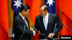 17일 호주 캔버라에서 정상회담을 가진 시진핑 중국 국가주석(왼쪽)과 토니 애벗 호주 총리가 악수하고 있다.