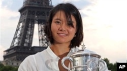 China's Li Na poses next to the Eiffel Tower after defeating Italy's Francesca Schiavone in their women's final match for the French Open tennis tournament at the Roland Garros stadium, June 4, 2011, in Paris.