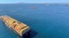 Kapal kontainer menunggu di lepas pantai Pelabuhan Los Angeles dan Long Beach yang padat di Long Beach, California, AS, 1 Oktober 2021.