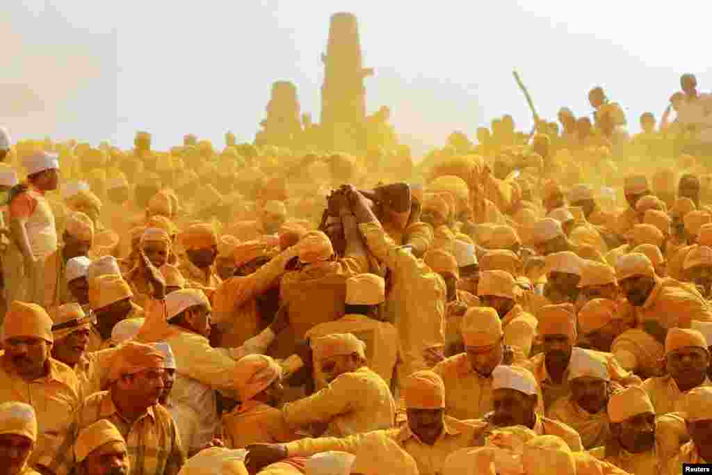 Devotees throw turmeric powder as an offering to the shepherd god Khandoba as others carry a palanquin during &#39;Somvati Amavasya&#39; at a temple in Jejuri, India, Feb. 4, 2019.