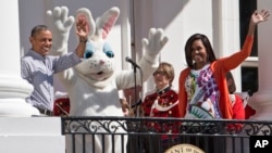 President Barack Obama and first lady Michelle Obama wave with the Easter Bunny as they greet families participating in the White House Easter Egg Roll on the South Lawn of White House in Washington, April 6, 2015.