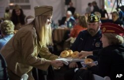 Volunteers provide donuts at an event honoring World War I "Donut Dollies," Nov. 9, 2018, in Washington. The event was hosted by U.S. World War I Centennial Commission and held at Pershing Park, site of the new National World War I Memorial. Nov. 11 marks the 100th anniversary of the end of World War I.