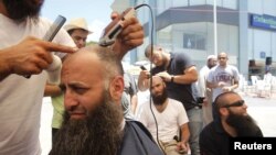 Ahmad Assir (L) and his supporters shave their heads during the sit-in in Sidon July 4, 2012.