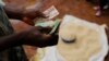 A Malawian trader counts money as he sells maize near the capital Lilongwe, Malawi, Feb. 1, 2016. 