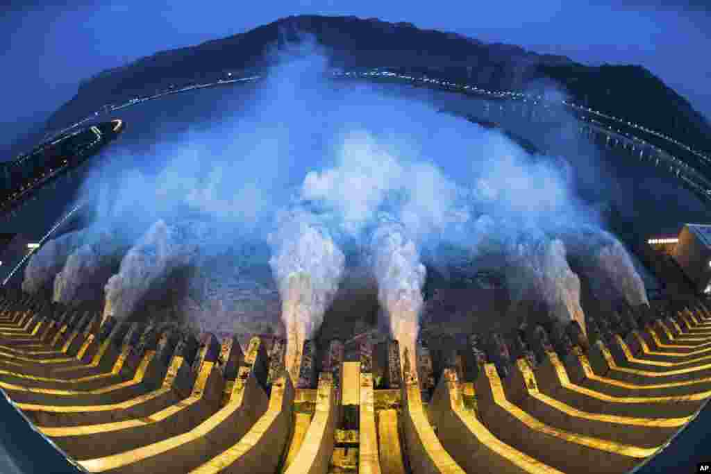 In this image made with fisheye lens and provided by Xinhua News Agency, floodwaters are discharged at the Three Gorges Dam in central China&#39;s Hubei province, July 19, 2020.