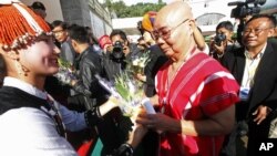 General Mutu Say Poe, second from right, Chairman of Karen National Union (KNU), receives flowers from a woman upon his arrival to attend ethnic armed organizations conference in Laiza, Burma, Oct. 30, 2013.
