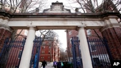 FILE - People walk through the gates leading to Harvard Yard, at Harvard University in Cambridge, Mass., Dec. 13, 2018.