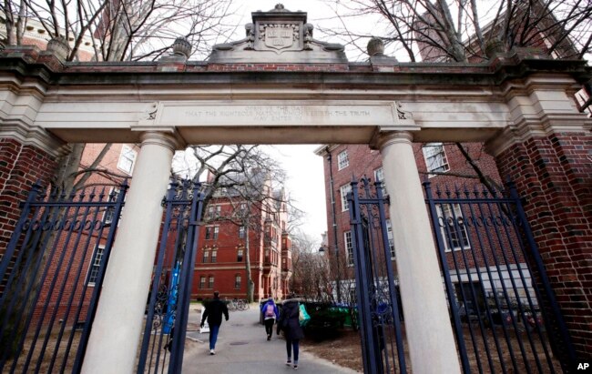 Orang-orang berjalan melewati gerbang menuju Harvard Yard, di Universitas Harvard di Cambridge, 13 Desember 2018. (Foto: AP)