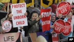 FILE - Protesters opposed to abortion hold placards outside a clinic in Belfast, Northern Ireland, Oct. 18, 2012. The New South Wales parliament in Australia is debating legislation to outlaw protests outside abortion clinics.