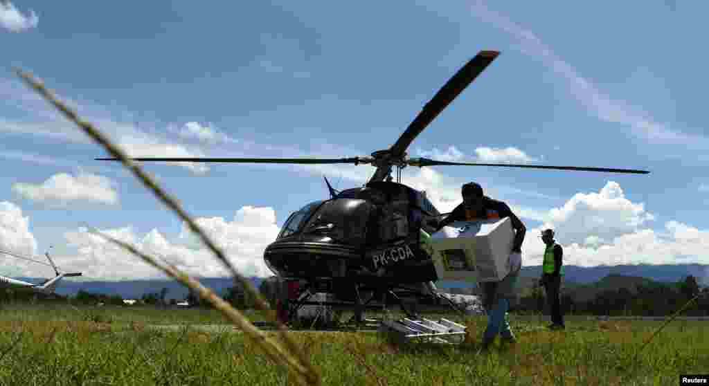 Seorang petugas membawa perlengkapan pemilu untuk dikirim dengan helikopter di Bandara Wamena, Jayawijaya, Papua, 13 April 2019. (Foto: Yusran Uccang/ Antara via Reuters)