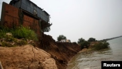 FILE - The remnants of a house built on the Mekong river banks is pictured after a portion of it collapsed when the soil underneath gave way, in Kandal province.