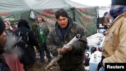 FILE - Oscar High Elk, 26, of the Cheyenne River Sioux Tribe, prays as he and other members of the tribe prepare to evacuate from the main opposition camp against the Dakota Access oil pipeline near Cannon Ball, N.D., Feb. 22, 2017. 