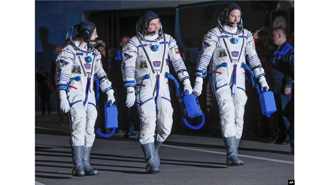 US astronauts Christina Hammock Koch (L), Nick Hague (R), and Russian cosmonaut Alexey Ovchinin, members of the main crew of the expedition to the International Space Station (ISS), walk before the launch of Soyuz MS-12 space ship at the Russian-leased Baikonur cosmodrome, Kazakhstan, March 14, 2019.