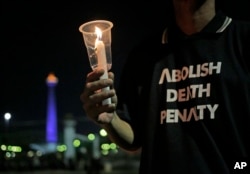 Seorang aktivis memegang lilin dalam doa bersama di luar Istana President, untuk memprotes hukuman mati, 28 Juli 2016.