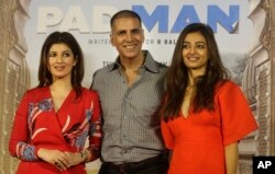 Bollywood actor Akshay Kumar, centre, with his wife Twinkle Khanna left, and Radhika Apte, right, pose for the media during the song launch of their film Pad Man in Mumbai, India, Dec. 20, 2017.