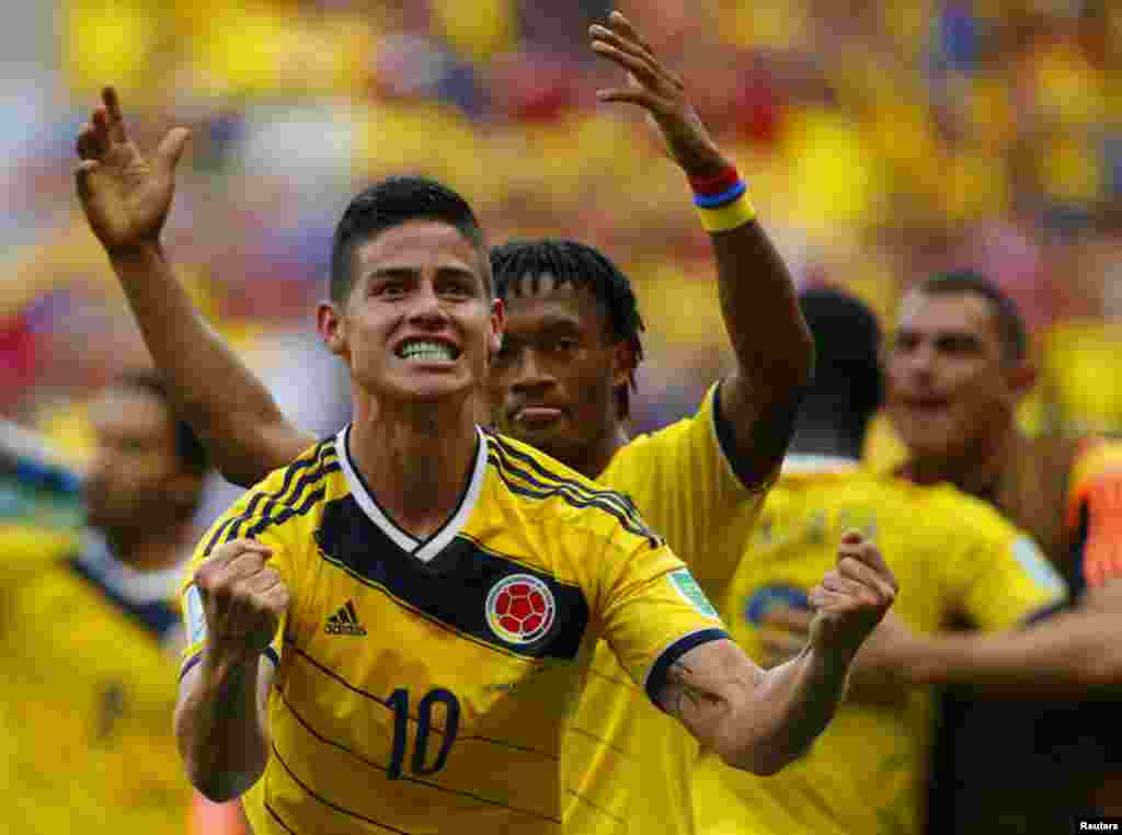 Os colombianos James Rodríguez e Juan Cuadrado (em segundo plano) celebram a vitória frente à Costa de Marfim, em jogo de fase de grupos, em Brasília, Junho 19, 2014