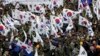 FILE - War veterans and members of conservative groups hold their national flags during a rally to call for unity between two Koreas, in Seoul, South Korea, March 1, 2015. 