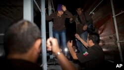 Immigration officials remove Central American migrants from a northbound freight train during a raid by federal police in San Ramon, Mexico, Aug. 29, 2014. 