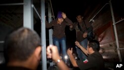 Petugas imigrasi menurunkan migran Amerika Tengah dari kereta barang yang menuju utara dalam penggrebekan oleh polisi di federal (29/8). San Ramon, Meksiko. (foto: AP Photo/Rebecca Blackwell)
