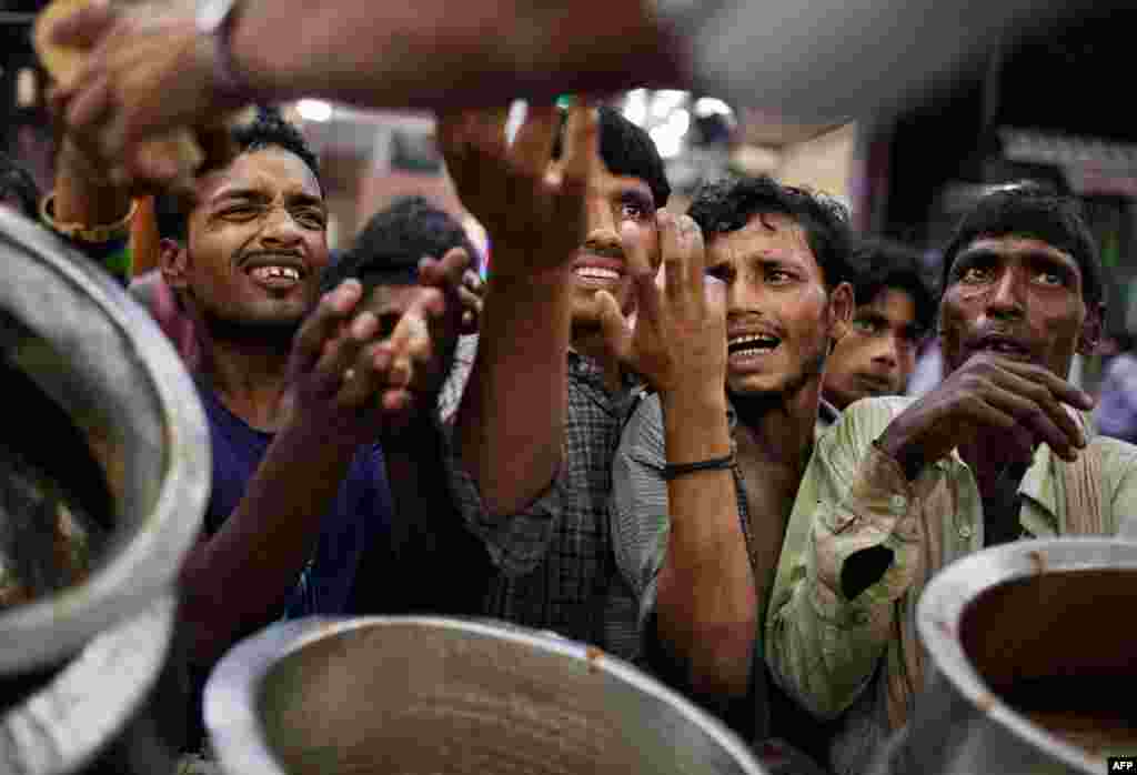 August 10: Impoverished Indian Muslims wait for food handouts before breaking the Ramadan fast at a restaurant near the Jama Masjid in New Delhi, India. The food is donated by wealthy local Muslims who give money to local vendors to feed the poor during I