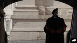 FILE - A Vatican Swiss guard stands on guard at the Vatican, Feb. 12, 2012. Money laundering at the Vatican bank. Corruption in the awarding of Vatican contracts. 