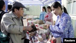 지난 2005년 8월 북한 개성을 방문한 한국인 관광객이 기념품 상점 판매원과 대화하고 있다.